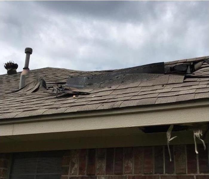 roof shingles on a house peeling back from fire damage