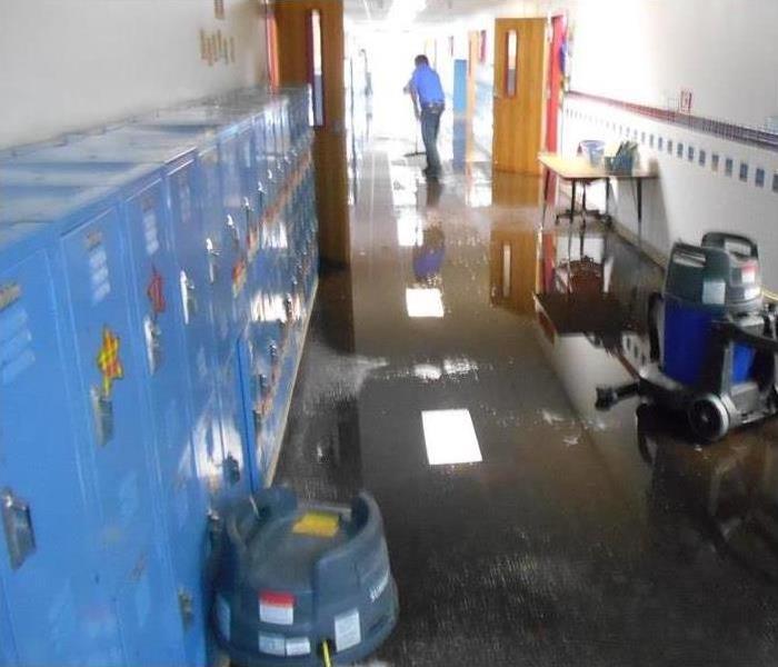 water flooding the floor of a school hallway